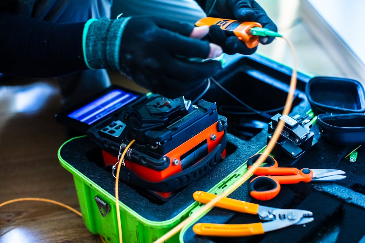 Fiber optic splicing cable tools and MikroTik equipment at job site for internet installation and repair