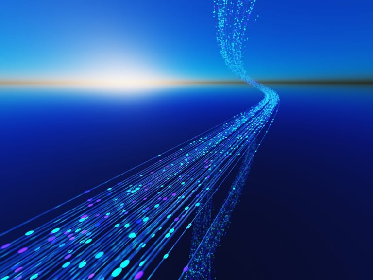 Abstract futuristic concept showing fiber optic light streams stretching across the ocean toward the horizon under a blue sky